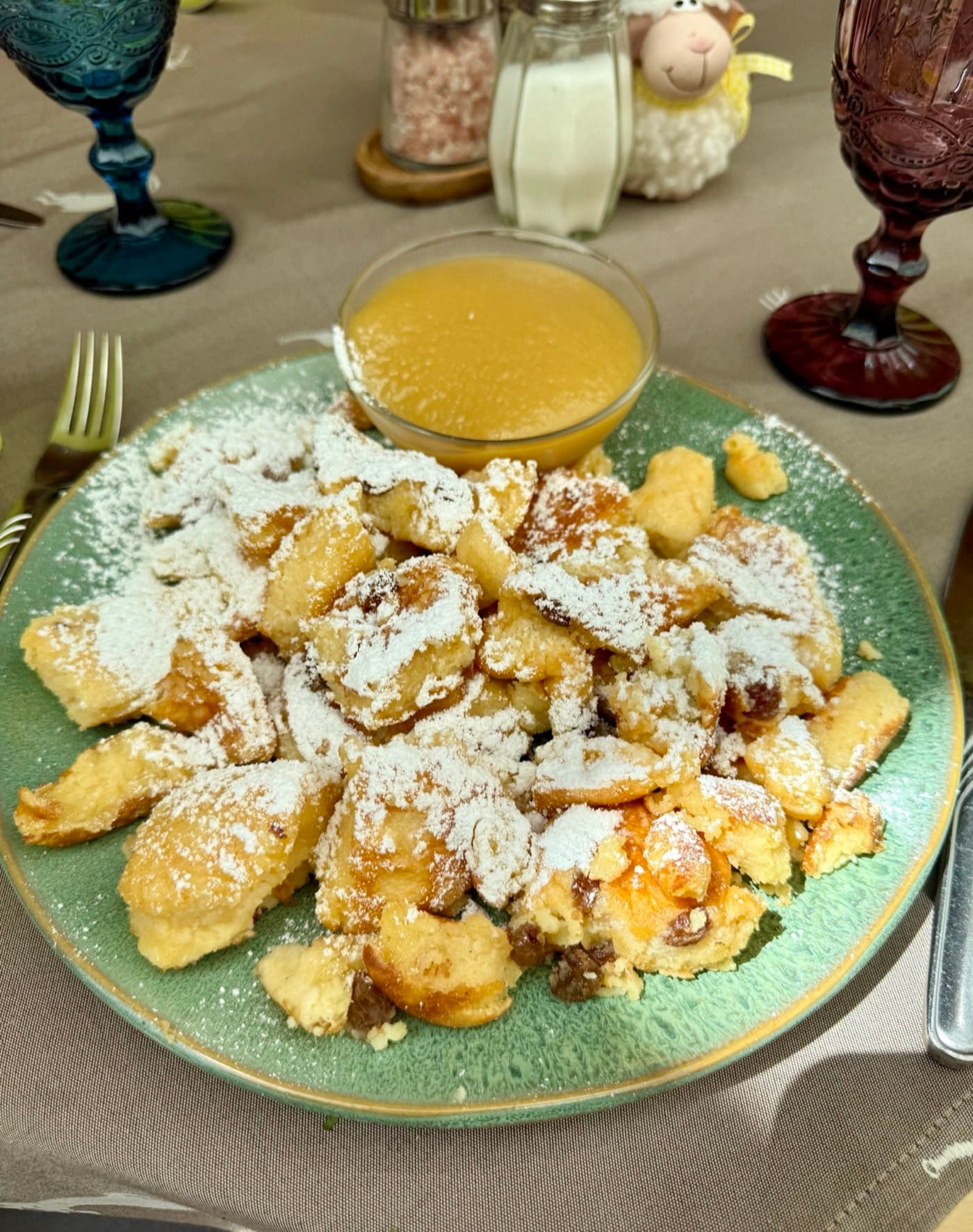 Fluffy shredded Kaiserschmarren pancake dusted with icing sugar, served with apple sauce at Zentrum Café Restaurant