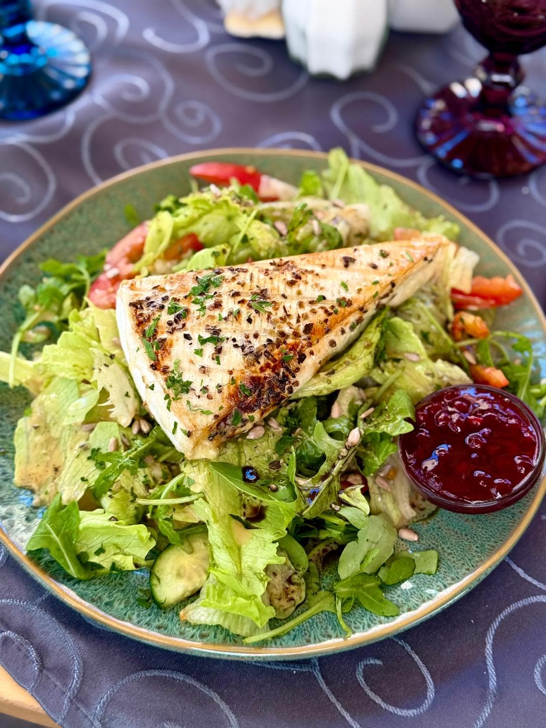Grilled cheese wedge on a fresh leaf salad with tomatoes, arugula, seeds and a cranberry dip at Zentrum Café Restaurant